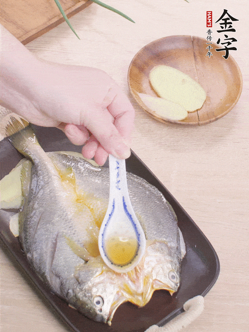 盤(pán)底鋪姜片，放黃魚(yú)，淋2勺料酒。